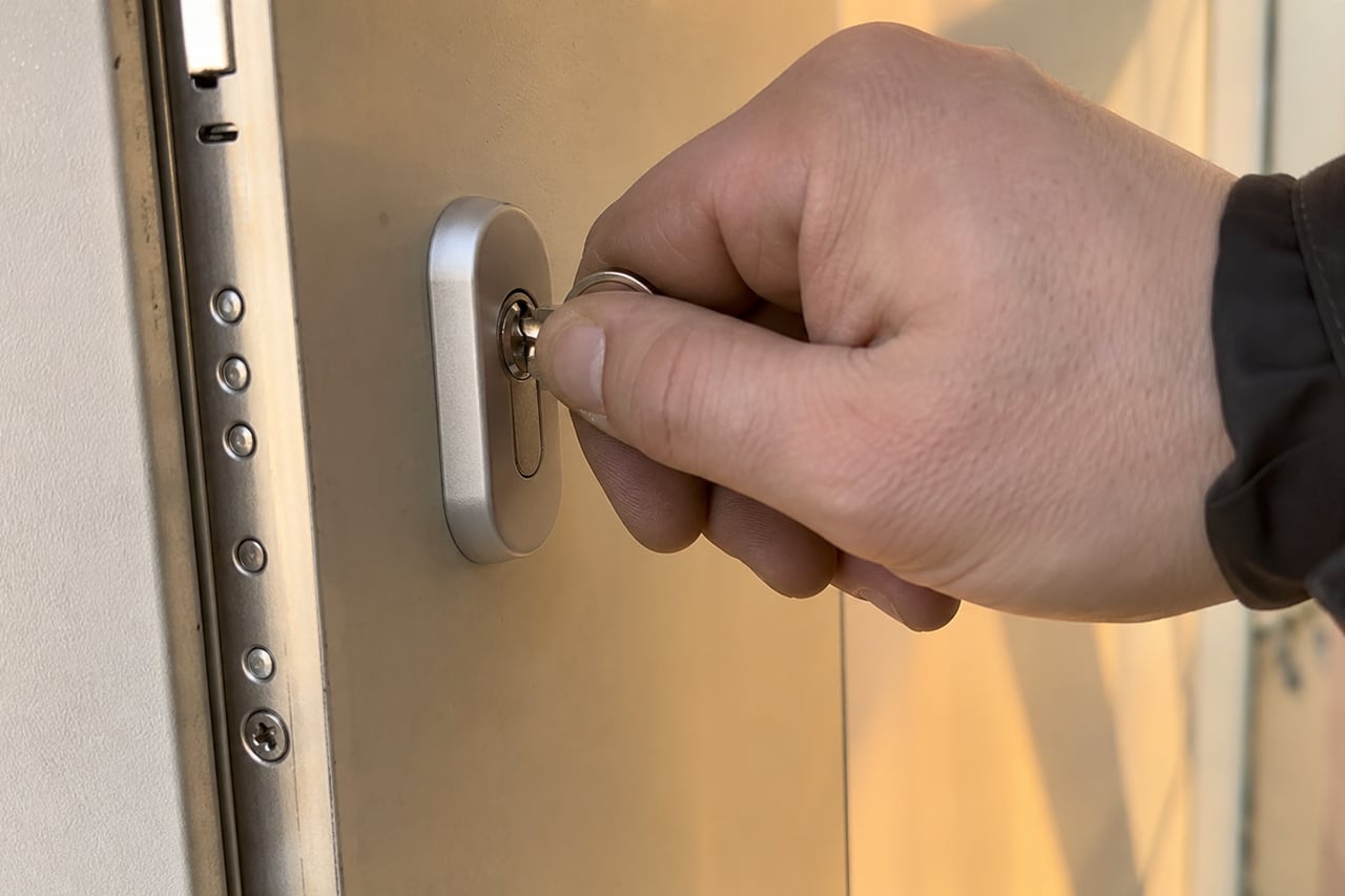 main tournant la clé dans un cylindre de porte
